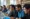 Grupo diversificado de pessoas em um ambiente educacional, usando laptops, representando aprendizagem colaborativa em cursos de inteligência artificial