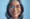 Close de uma mulher sorrindo, com um círculo azul digital ao redor de seu rosto, simbolizando a tecnologia de reconhecimento facial impulsionada pela inteligência artificial.