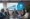 Executivos em uma reunião corporativa analisando gráficos e resultados específicos em uma tela, com o logotipo do Zoho em destaque